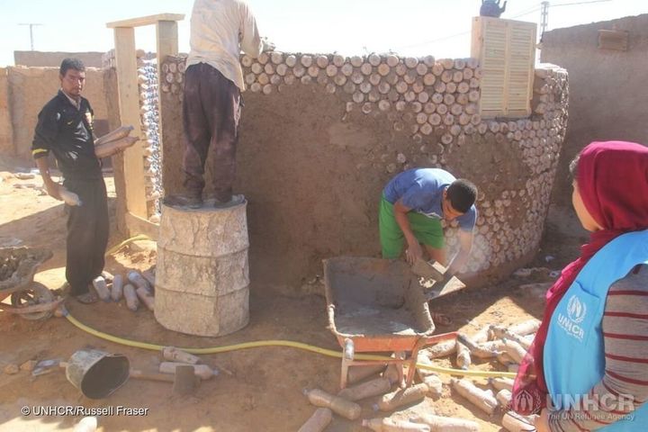 building a home using sand-filled plastic bottles for new refugees in SE Algeria